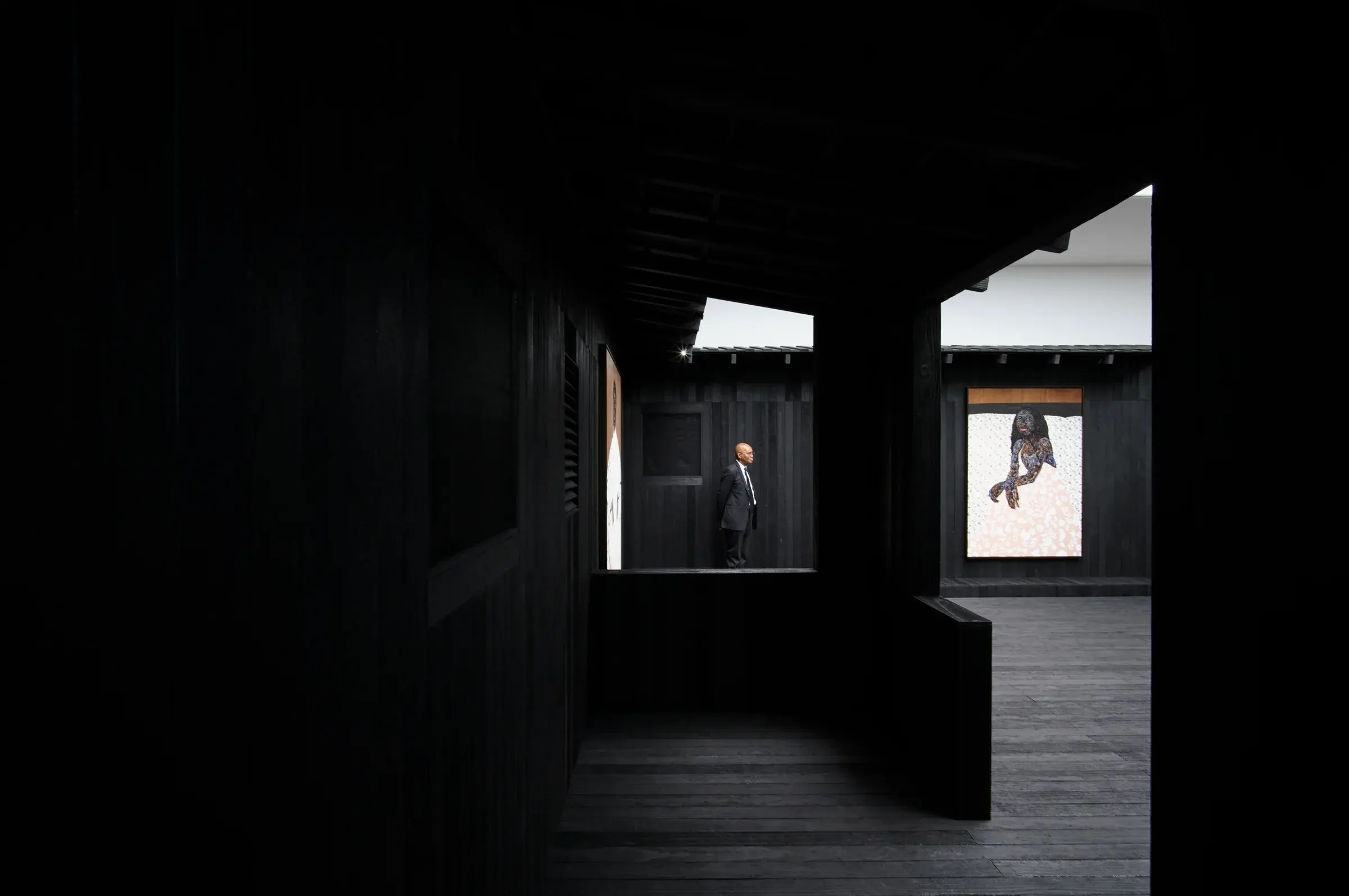 Charred timber pavilion and framed paintings at Awulai Ashia & Nkyinkyim Exhibition at Gagosian in London, Photography Julien Lanoo