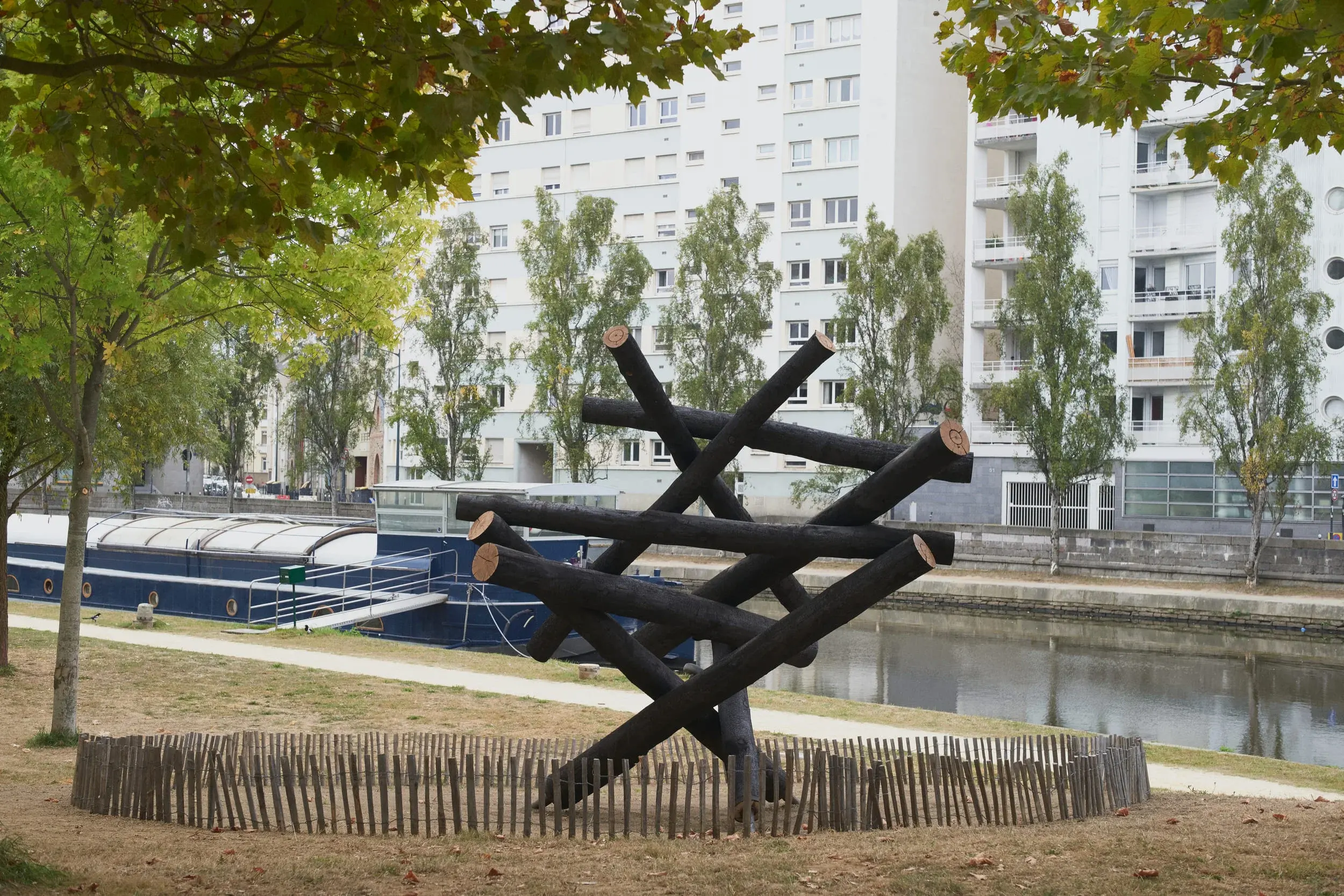 Dancing Forest by Kengo Kuma on the Saint-Cyr quays in Rennes, France, with burnt wooden trunks and Photography Julien Lanoo