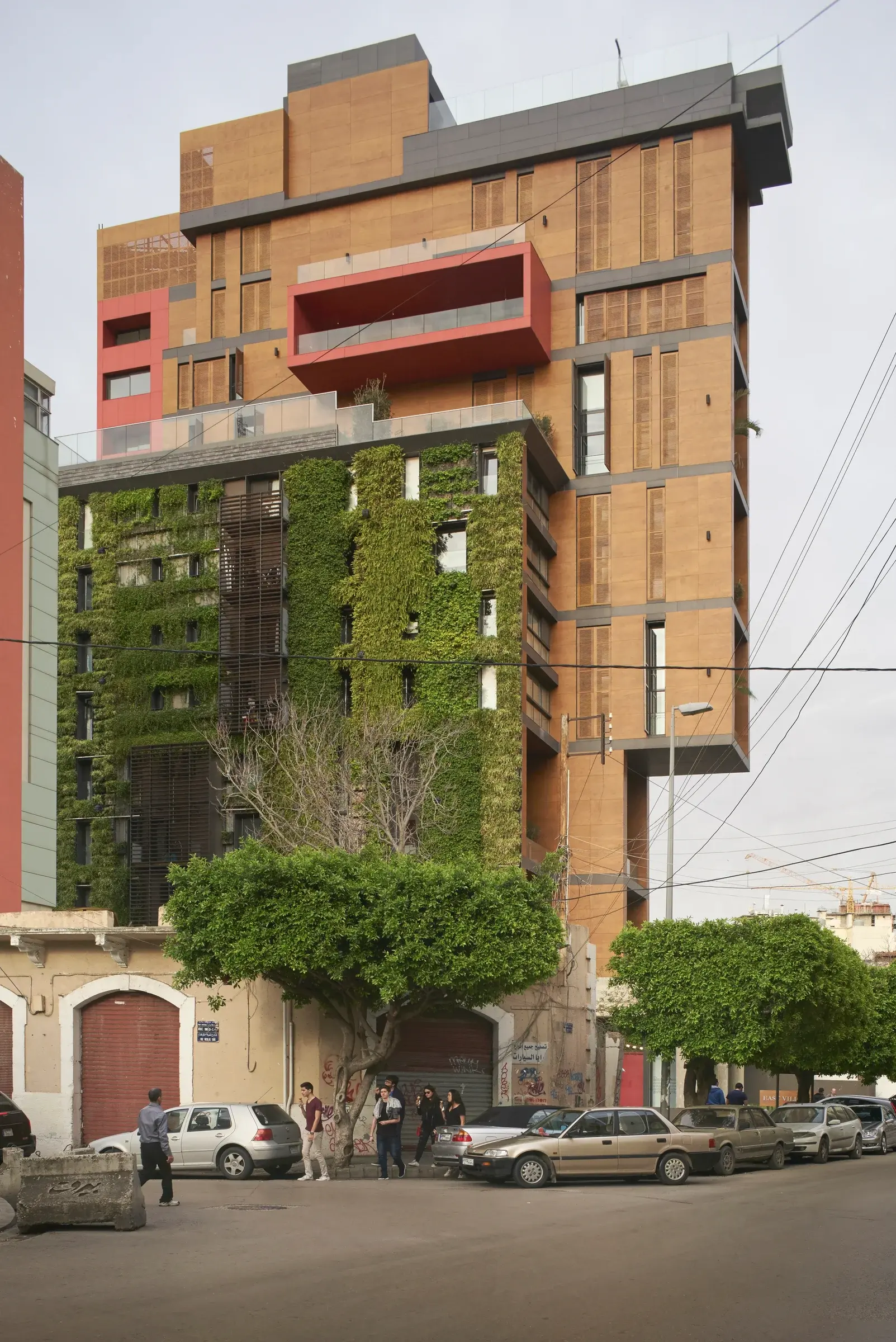 East Village, Beirut, Lebanon, with dark stone and timber façades rising above a planted base