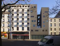 Street-level view of the stepped corner façade of the Goutte d’Or Care Centre and Reintegration Housing in Paris