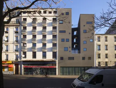 Street-level view of the stepped corner façade of the Goutte d’Or Care Centre and Reintegration Housing in Paris