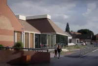 Les Acacias Sociocultural Centre in Abscon, France, with glazed façades and a concrete portico
