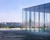 Louvre-Lens museum by SANAA in Lens, France, with low reflective volumes in a park setting, Photography Julien Lanoo