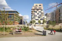 Residential facade by TVK in Saint-Ouen-sur-Seine with layered balconies and a strong urban presence