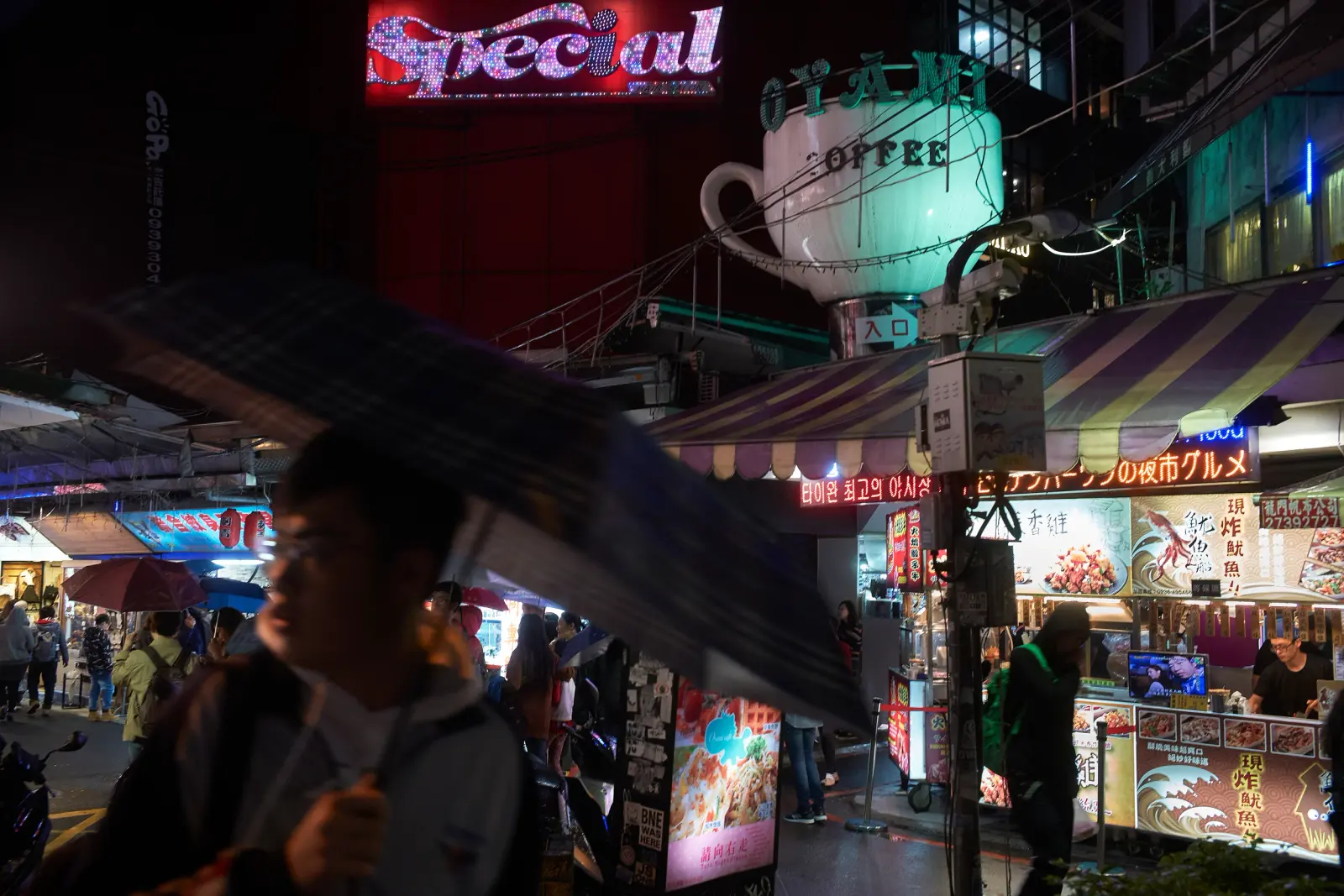 Night street scene in Taipei, Taiwan, with illuminated signage and reflections, Photography Julien Lanoo