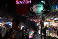 Night street scene in Taipei, Taiwan, with illuminated signage and reflections, Photography Julien Lanoo