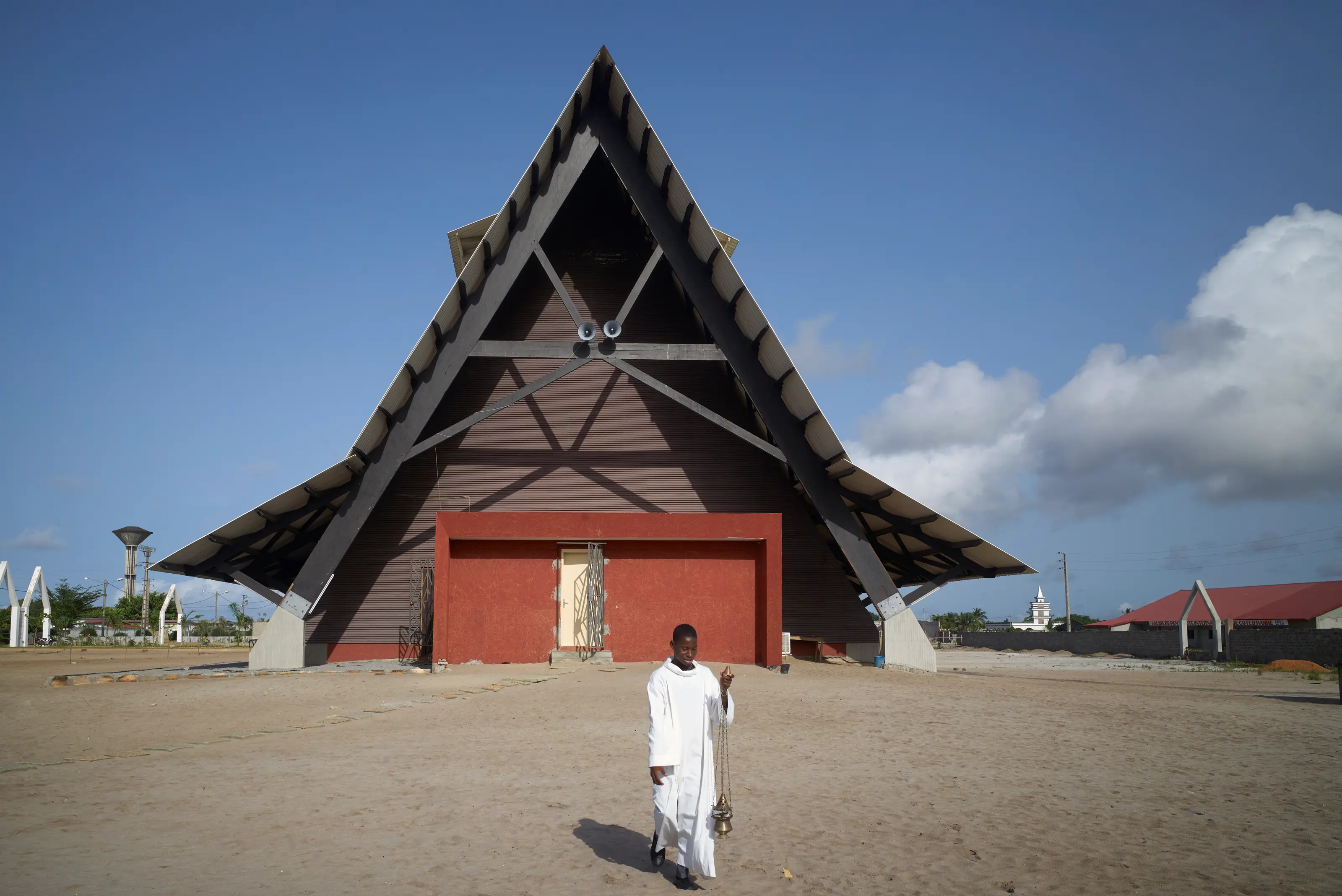 The Assinie-Mafia Church by Koffi & Diabaté Architectes in Assinie-Mafia, Côte d’Ivoire, with a steep triangular roof and open sides, Photography Julien Lanoo